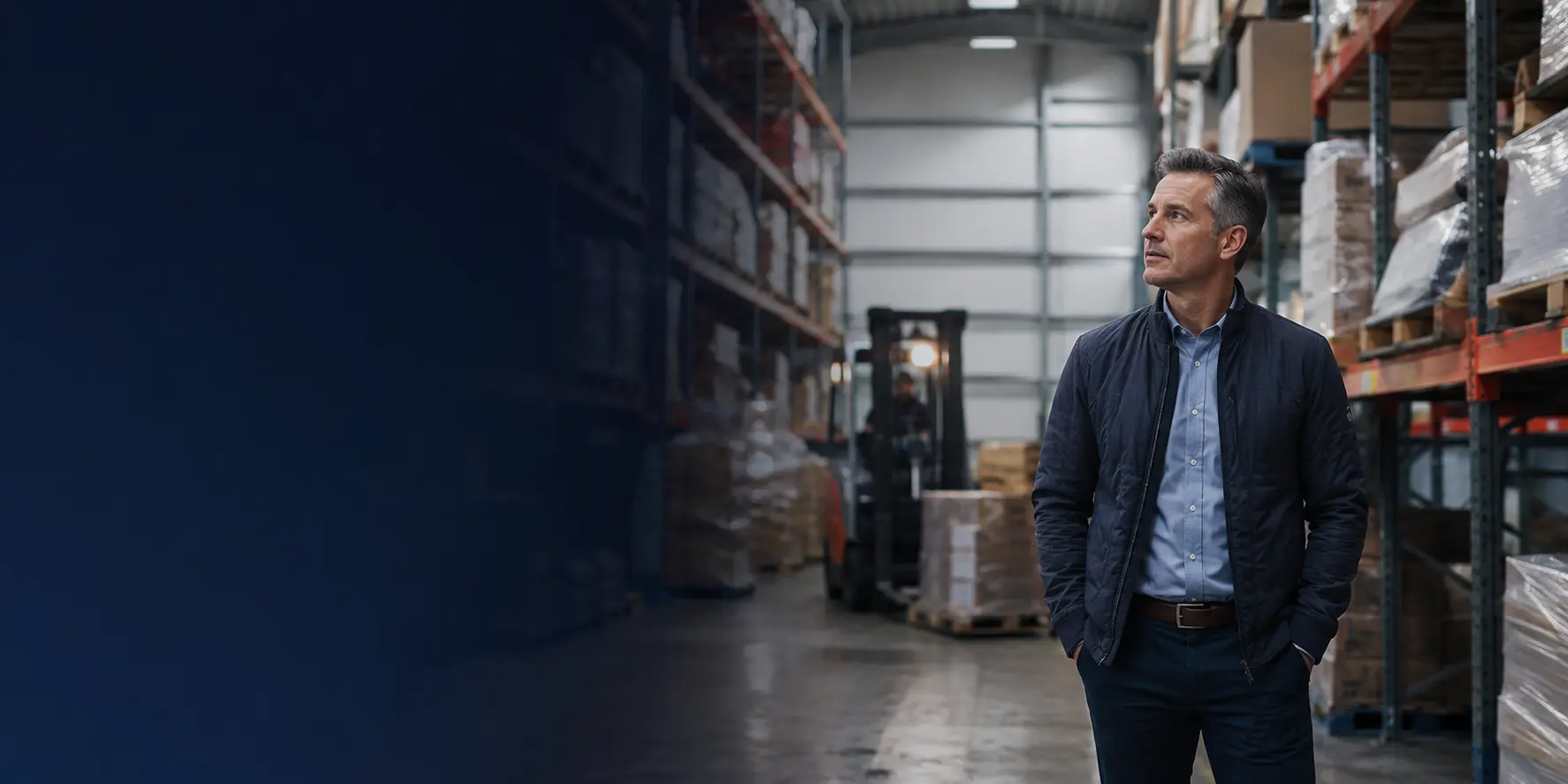 A distribution business owner reviewing inventory inside a working warehouse